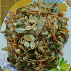 Cho hoa chuối, cà rốt, tai heo, thịt, rau thơm vào cùng nước trộn nộm trộn đều lên để tầm 10 phút cho ngấm gia vị là dùng được.