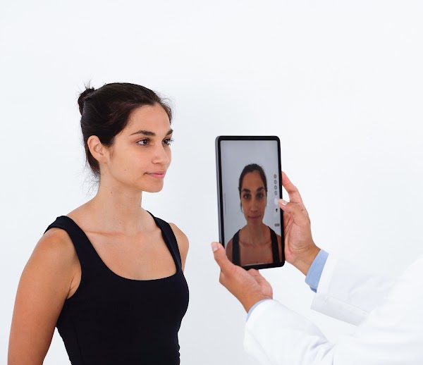 Le médecin prend une photo du profil avant du patient avec une tablette pour créer un modèle 3D avec Crisalix.