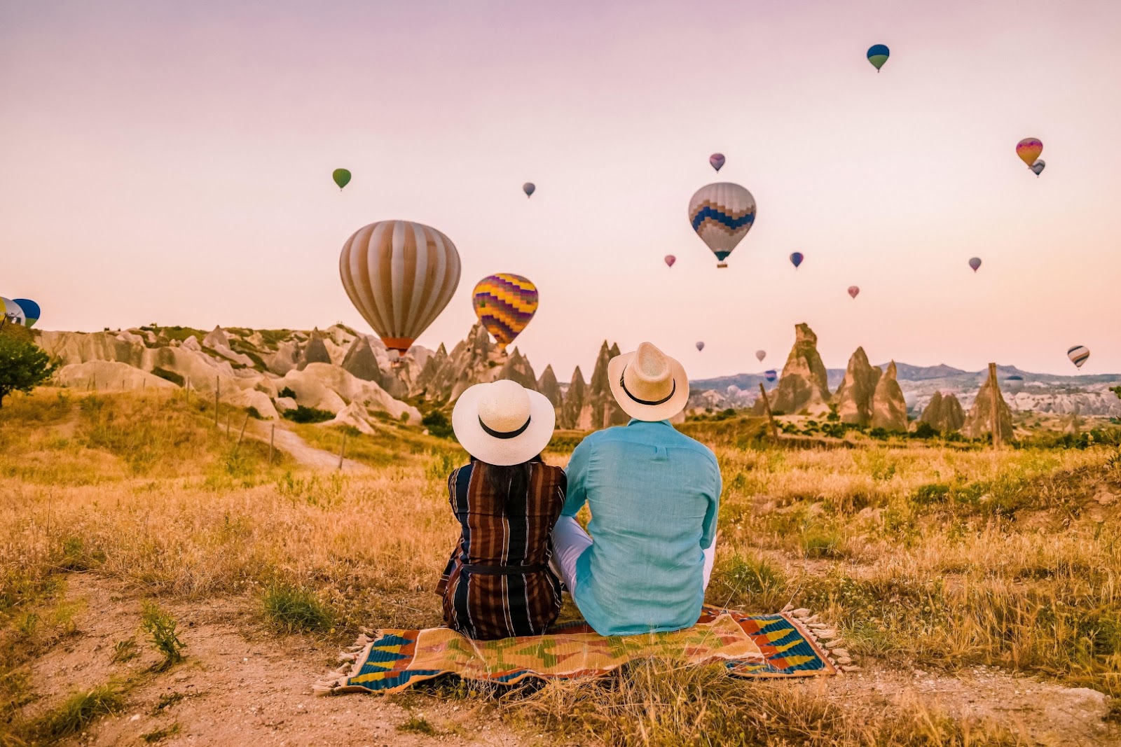 Colorful hot-air balloons filling the sky above Cappadocia’s dramatic rock formations at sunrise.