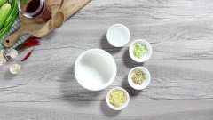 Phần quan trọng và là linh hồn của món đây rồi. Đó là nước sốt tỏi cay "thần thánh". Cho ½ muỗng canh gừng băm, 3 muỗng canh tỏi băm, 1 muỗng canh gốc hành cắt nhuyễn và 2 muỗng canh giấm vào một bát nhỏ, ngâm từ 5-10 phút. Tiếp tục cho vào bát nước tỏi đã ngâm nửa muỗng canh muối, 2 muỗng canh đường, 4 muỗng canh ớt sa tế, 2 muỗng canh nước tương, 1 muỗng canh nước rồi trộn đều hỗn hợp.