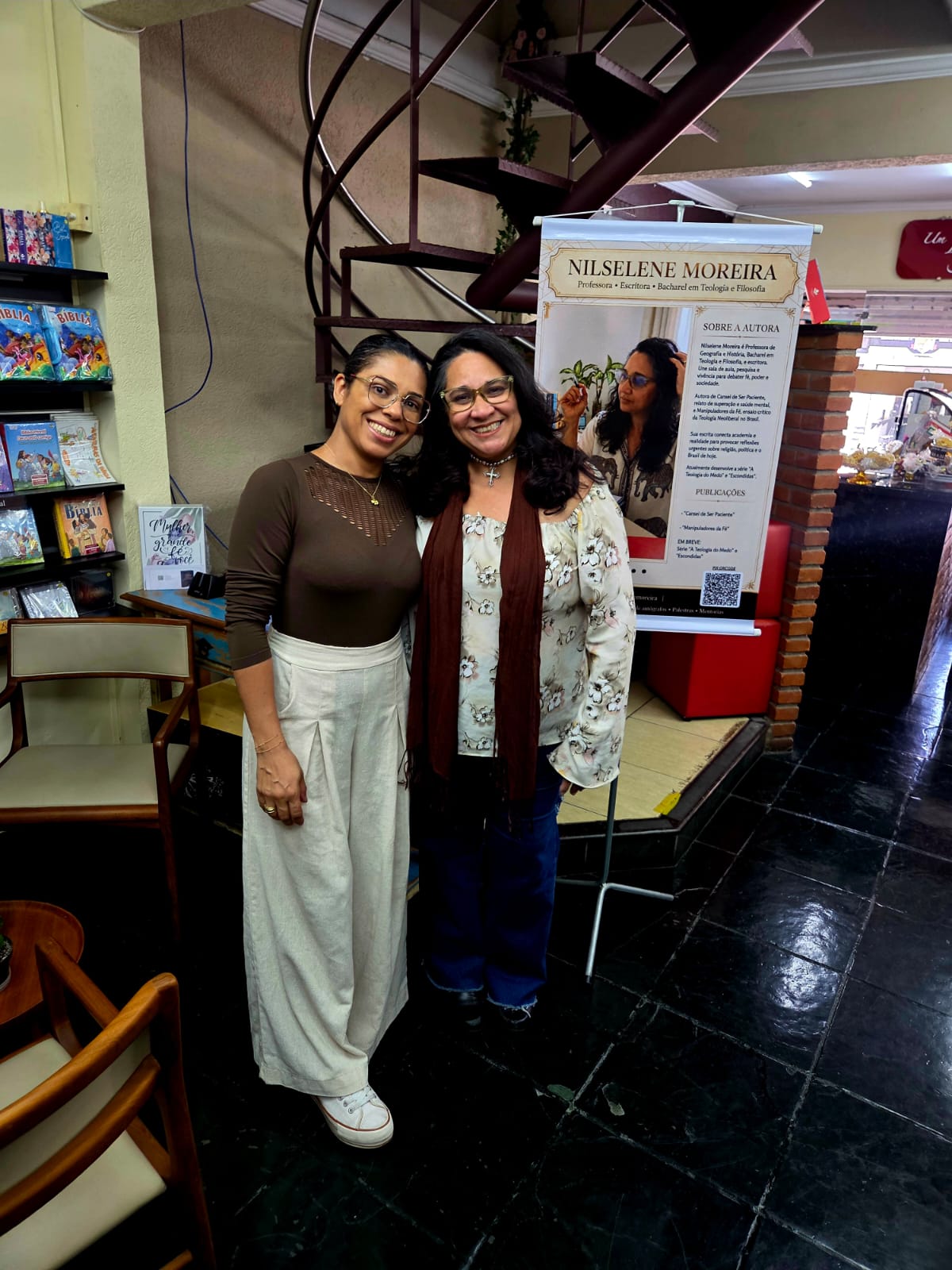 Nilselene com o banner do evento