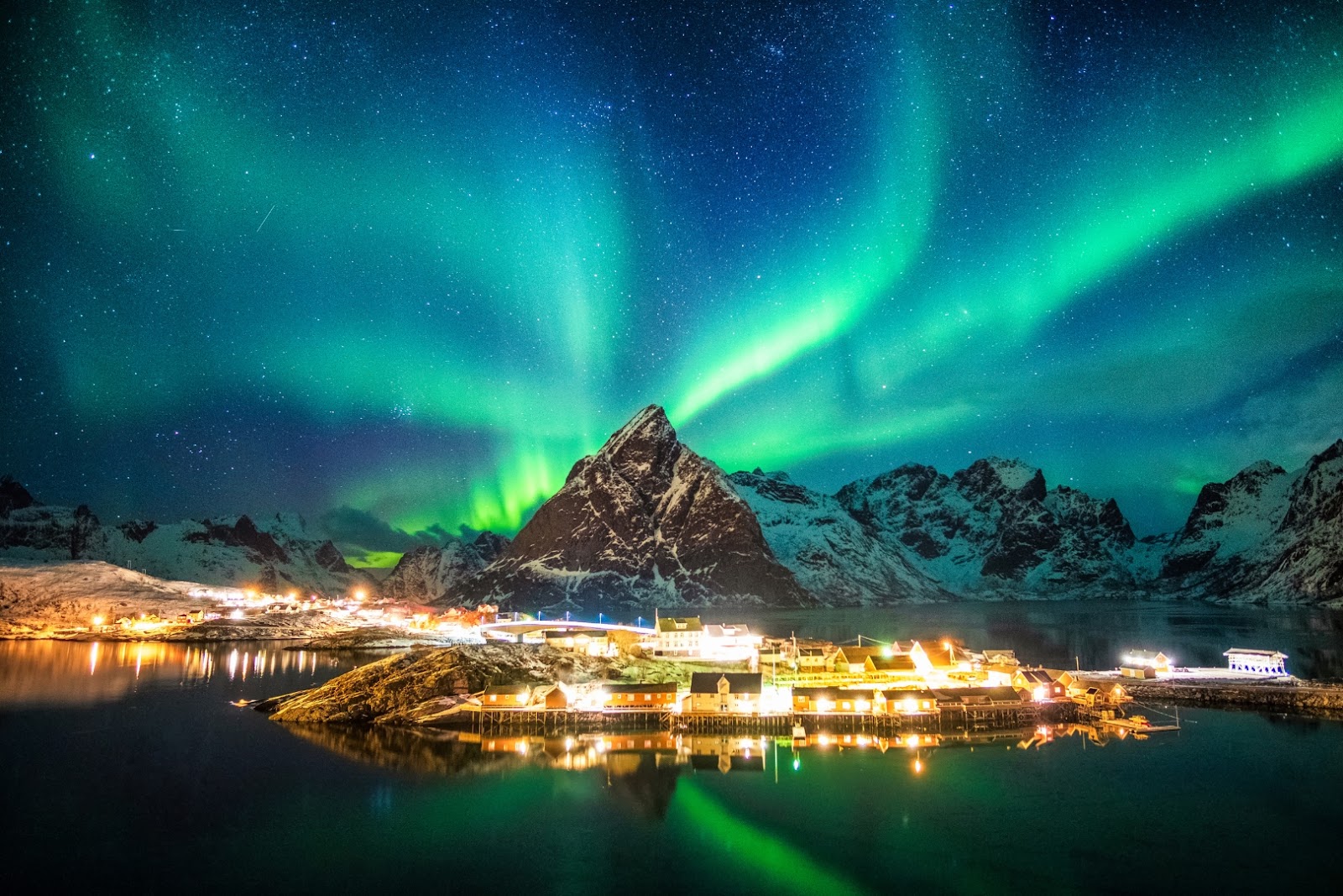 Northern Lights illuminating the dramatic mountains and coastal scenery of Norway’s Lofoten Islands.