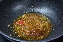 Phi thơm tỏi băm với 2 muỗng canh dầu ăn. Cho vào 2 muỗng canh đường, 3 muỗng canh nước mắm, 1 muỗng canh tương ớt, khuấy đều cho hốn hợp tan rồi thêm vào ớt đã cắt nhỏ.