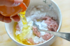 Tiếp đến cho thịt cùng gừng, hành vào cối xay thịt, xay nhuyễn. Cho bột mì, lòng trắng trứng, muối vào trộn đều với thịt.