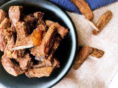 Khi thịt bò đã ướp xong cho vào nồi cơm điện, nhấn nút cook và nấu đến khi nồi chuyển sang nút warm thì trộn đều thịt bò và lấy ra tô, thêm ớt bột, bột thì là vào để tạo thêm hương vị. Sau đó trải đều thịt bò ra khay và đem để nơi thoáng gió từ 12 - 24 giờ cho thịt bò khô lại. Hoặc bạn có thể cho vào lò vi sóng 1 - 2 phút để xấy khô cũng được.