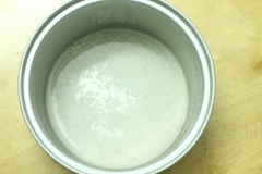 Vo sạch gạo và đem đi nấu cơm. Canh nước nhiều hơn bình thường để gạo nhão.