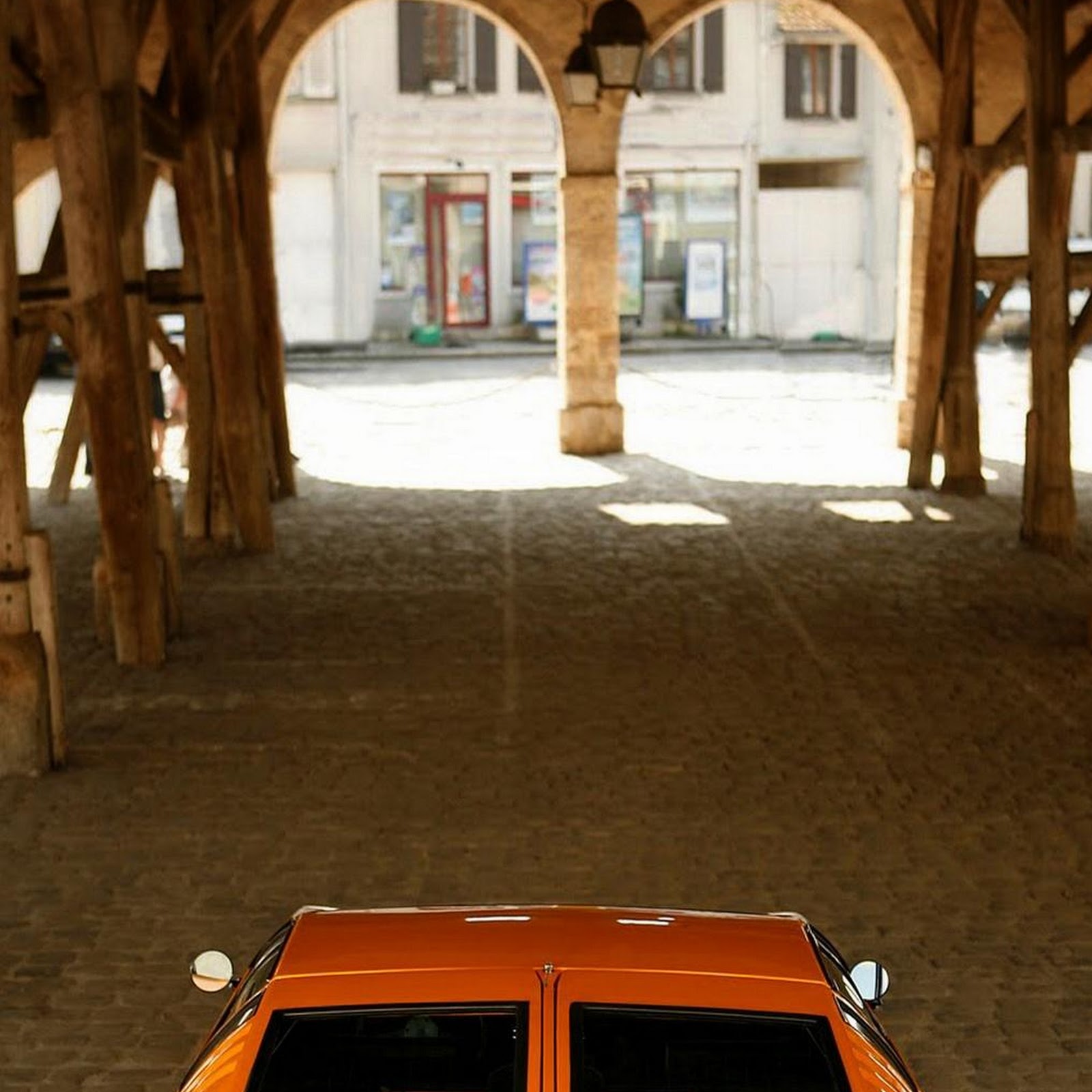 Download Orange Lamborghini Under Wooden Archway iPhone