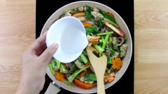 Tiếp tục thêm cà chua xắt múi cau (1 quả xắt làm 8), 1 muỗng canh bột năng pha loãng với 2 muỗng canh nước vào để tạo độ sêt. Cuối cùng thêm cần tàu xắt khúc vào, đảo đều rồi nhắc xuống là hoàn thành mì xào giòn.