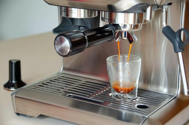 Caffè versato dalla macchina per caffè espresso Breville The Barista Express in una tazza di vetro