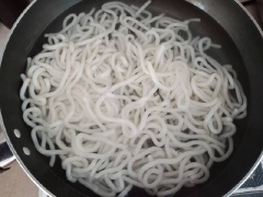 Đun sôi nồi nước khác cho mì Udon vào chần, vì là mì tươi nên chỉ cần chần cho mì tơi ra là được. Đổ mì ra rổ ráo nước rồi chia mì vào từng tô.