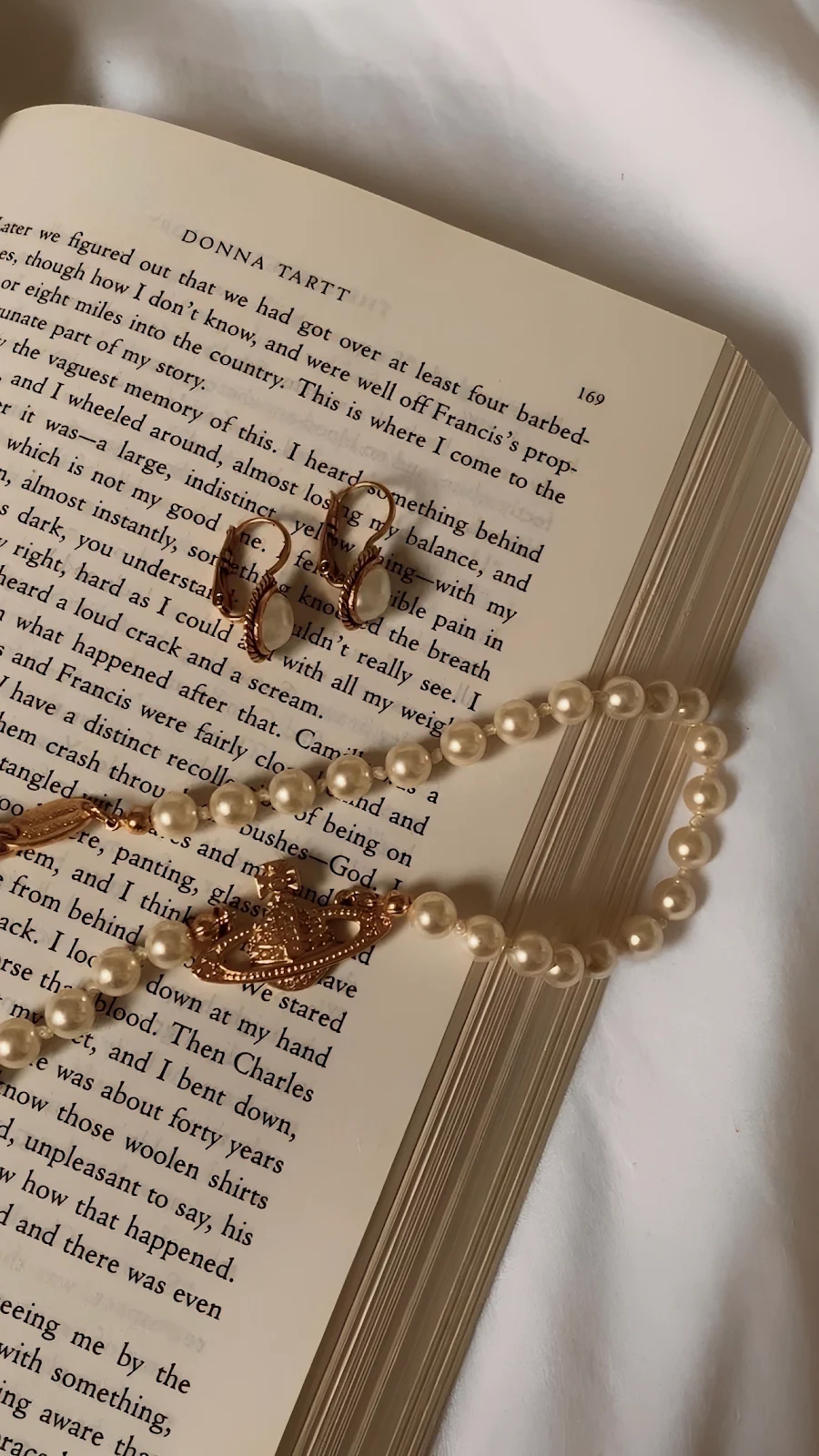 Vivienne Westwood Necklace on Book - Aesthetic Still Life Full HD iPhone Wallpaper (1287x2288)