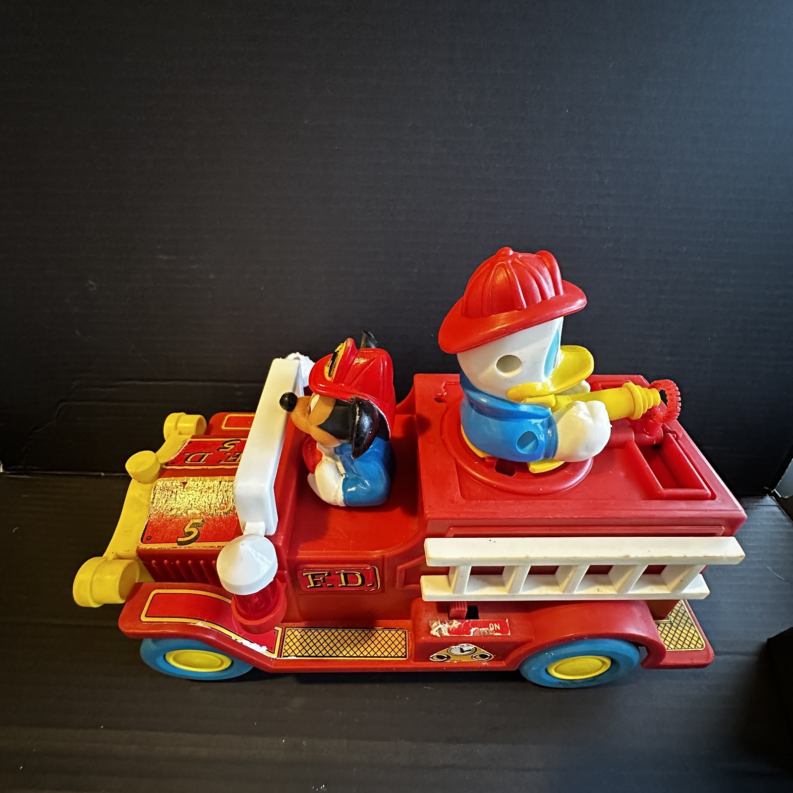 Red battery-operated bump-and-go Disney fire engine toy featuring Mickey Mouse and Donald Duck, circa late 1970s to early 1980s