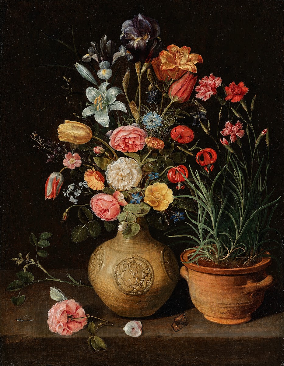 Roses lilies an iris and other flowers in an earthenware vase with a pot of carn