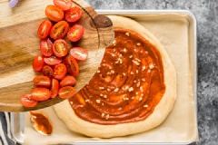Lần lượt xếp cà chua bi lên bánh, phô mai mozzarella cũng xếp đều lên trên. Húng quế thái sợi, rắc lên. Cho bánh vào lò nướng tâm 15 phút là bánh chín.