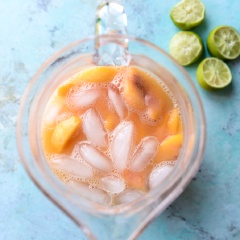 Đào và thơm rửa sạch, gọt vỏ, thái nhỏ. Cho đào, thơm, siro đường, nước, nước đá vào máy xay sinh tố và bật công tắc xay nhuyễn hỗn hợp.