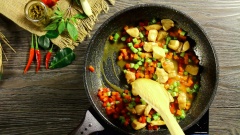 Khi sốt cà ri sôi cho vào chảo phần thịt gà đã ướp cùng 50gr cà rốt, 50 gr đậu côve và 50gr ớt chuông cắt hạt lựu. Đảo đều đến khi gà gần chín thì cho 200gr cơm vào trộn đều với nhau. Phần cơm để chiên nên nấu hơi khô một chút để khi đảo cơm sẽ không bị quá dính, gây ngán khi ăn. Cuối cùng rắc lá chanh và lá húng quế vào phần cơm đã trộn cho thơm. Vậy là món cơm chiên cà ri xanh đã hoàn thành.