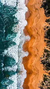 Aerial Top-Down View of Teal Ocean Waves Meeting Vibrant Orange Sands