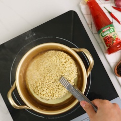 Bắt nồi nước sôi, cho 2 gói mì vào nấu trong vòng 3 phút để mì vừa chín tới, không để quá mềm, sau đó vớt ra để ráo nước.