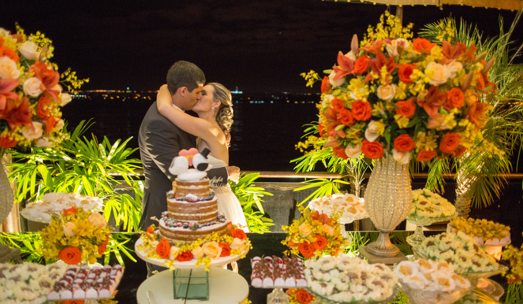 Casal em celebração noturna na Oca do Lago, palco dos signature events da Joli Experience