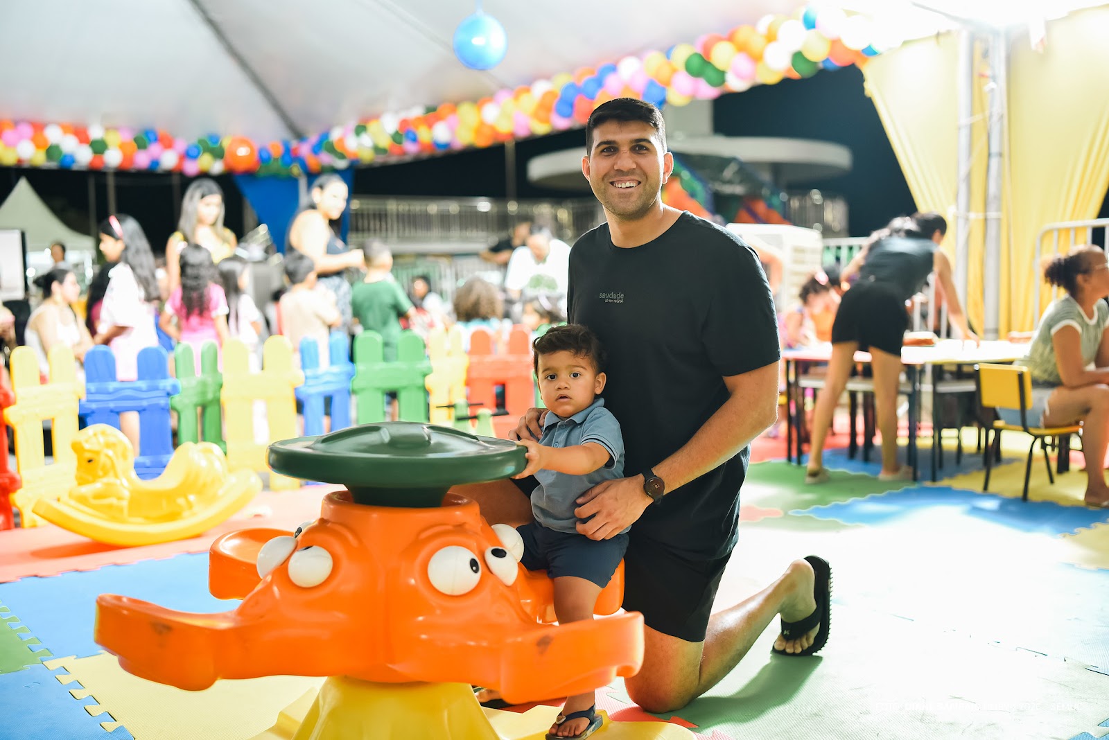 Pais e filhos brincam em escorregadores infláveis gigantes no Parque do Rio Branco durante o festival Mormaço.
