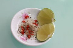 Trong khi chờ gà nguội, cắt sợi lá chanh. Chuẩn bị đồ chấm gà: muối, tiêu, ớt cắt lát và vài miếng chanh. Ngay trước khi ăn mới vắt chanh nhé!