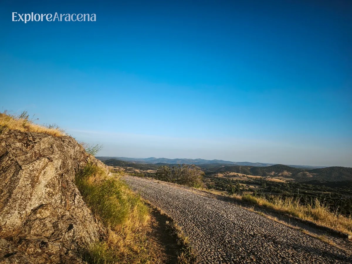 Scenic viewpoint overlooking rolling green hills in the Sierra de Aracena.