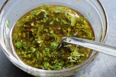 Mở lò nướng ở 200 độ C. Tỏi để nguyên củ, cắt một chút ở phần đầu rồi đặt lên giấy bạc, rưới dầu olive, muối và tiêu lên trên sau đó đem nướng khoảng 15 - 20 phút thì lấy tỏi ra. Làm nước sốt: cho 2 muỗng dầu olive, nước cốt chanh, tương ớt, nước tương, mật ong, ớt bột và ngò vào tô trộn đều, tiếp đó cho tỏi đã nướng vào và khuấy đều.