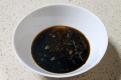 Làm sốt trộn huyết heo chua nóng: ngò rí thái nhỏ, 10g mù tạt, 15g muối, 10ml nước tương, 2g tiêu, 25g dầu ớt và 25ml giấm trong một cái bát, khuấy đều cho tan gia vị.