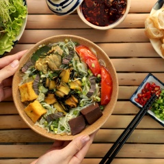 Cho bún ra tô, cho các topping vào rồi múc nước dùng vào rồi rắc hành, ngò gai và lá tía tô thái nhỏ vào. Món ăn này dùng kèm với rau sống và ớt chưng sẽ tăng thêm hương vị ngon vốn có của món bún.