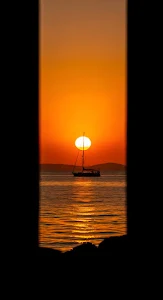 Sailboat Silhouette Framed by Black Bars at Sunset