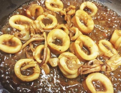 Đặt chảo lên bếp, cho 1 muỗng canh dầu ăn, dầu nóng cho tỏi bằm vào phi thơm. Sau đó cho mực vào đảo săn lại. Tiếp đến cho hết chỗ nước sốt me còn lại vào, thêm 1 muỗng canh nước mắm, 1 muỗng canh đường, 1 muỗng cà phê hạt nêm, đun thêm khoảng 1-2 phút cho nước sốt sánh lại. Tắt bếp, cho gừng đã thái sợi và ớt vào đảo đều. Cho mực sốt me ra đĩa và thưởng thức nhé!