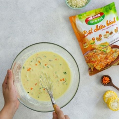 Pha 200gr bột chiên bánh Vedan với 260gr nước rồi trộn đều. Băm nhỏ bắp cải trắng, cà rốt cắt hạt lựu nhỏ, hành lá băm nhỏ. Cho bạch tuộc, bắp cải trắng, hành lá và gừng ngâm chua vào tô bột rồi trộn đều.