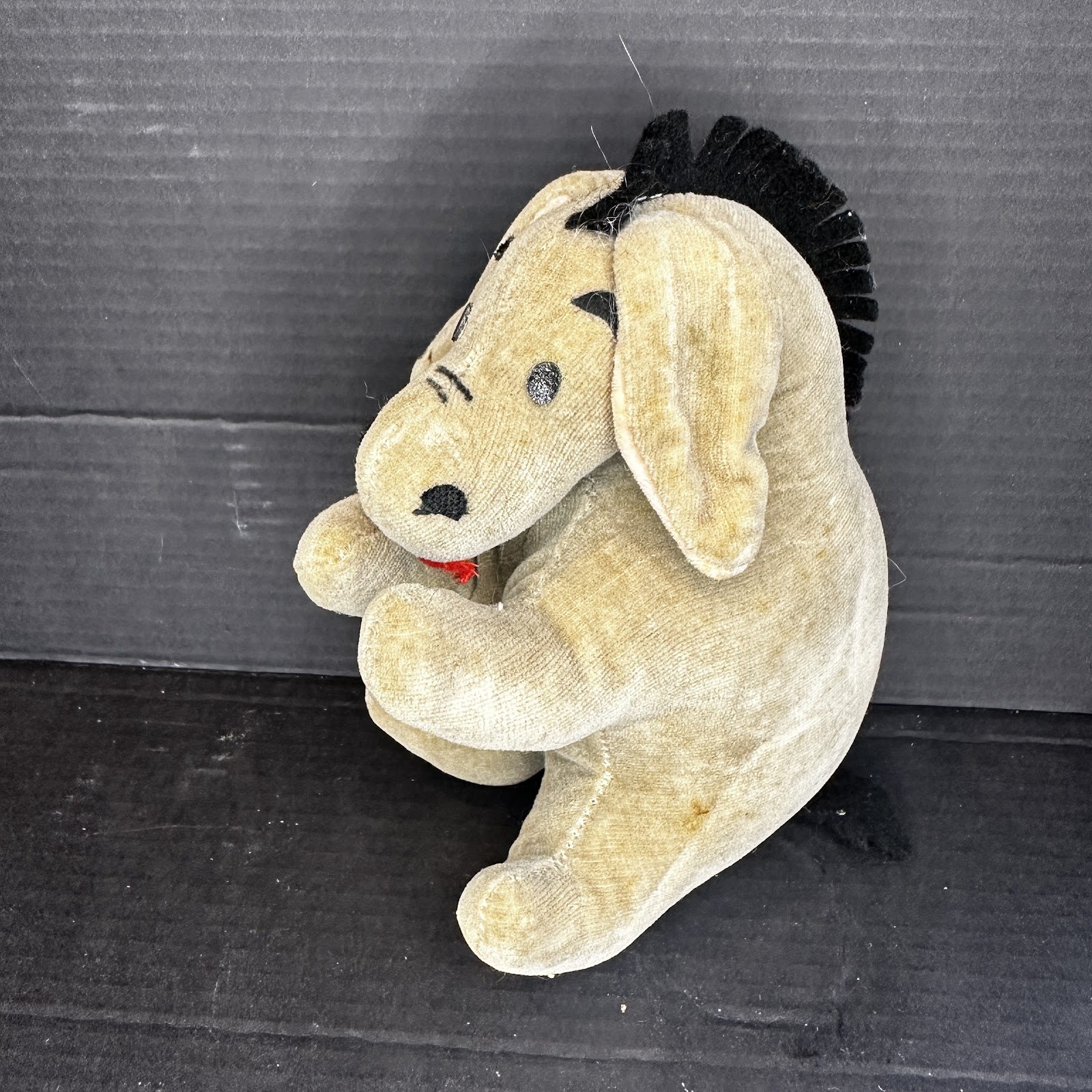 Vintage mid-century Eeyore stuffed animal in velveteen fabric, grey and blue tones, showing age-related staining consistent with decades of use