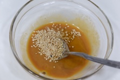 Cuối cùng thêm mè trắng vào tô sốt trộn salad, khuấy cho quyện đều lên là có thể sử dụng.