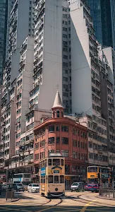 Busy Hong Kong Street Scene with Trams and Tall Buildings in Mid-day Sun