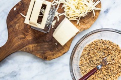 Bật trước lò nướng ở nhiệt độ 350 độ F. Phủ giấy nến lên khay nướng. Cho bột mì vào tô, kế đó là ớt bột, bột nở, trộn đều hỗn hợp. Cho bơ lạt vào tô, dùng nĩa trộn đều. Cuối cùng là mè đen và phô mai, dùng tay trộn đều hỗn hợp trộn lẫn vào nhau.