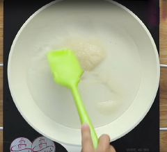 Cho nước dừa cùng đường vào chảo, khuấy đều để đường tan hết và đun cho đến khi hỗn hợp nước sôi lên. Cho thêm cốm khô vào đảo đều.