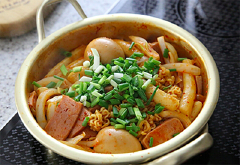 Khi bánh gạo đã mềm, bạn cho vắt mì vào cùng. Đun đến khi nước cạn bớt và mì chín thì bạn trộn đều mì lên cho thật ngấm sốt, sau đó rắc thêm hành lá lên trên là hoàn tất rồi.