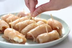 Bước tiếp thoe vô cùng đơn giản, đó là đặt miếng phô mai đã cắt vào phần thịt gà, dùng tay cuộn chặt một xíu và cố định bằng tăm.