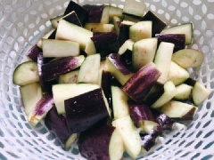 Vớt cà tím ra, để ráo nước. Đặt chảo lên bếp, thêm vào dầu ăn, sau đó phi thơm tỏi, đổ cà tím vào xào sơ, thêm vào 2 thìa cà phê hạt nêm và đảo đều.