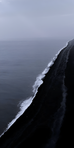 Stark Black Sand Beach and Moody Ocean Coastline View