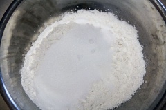Trộn bột mì, đường chung với nhau, sau đó chia 2 phần. Dùng 150g bột bánh bao trộn với khoai lang tím vừa nghiền, 200 g bột bánh bao còn lại mình để tô riêng.