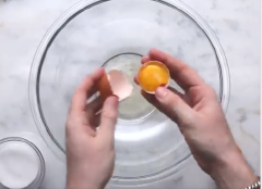 Tách lấy 3 lòng trắng trứng, dùng máy đánh trứng đánh bông lòng trắng trứng rồi cho vào thêm 50gr đường trắng đánh tan. tiếp theo cho 350gr đường bột và 200gr bột hạnh nhân rồi trộn đều hỗn hợp.