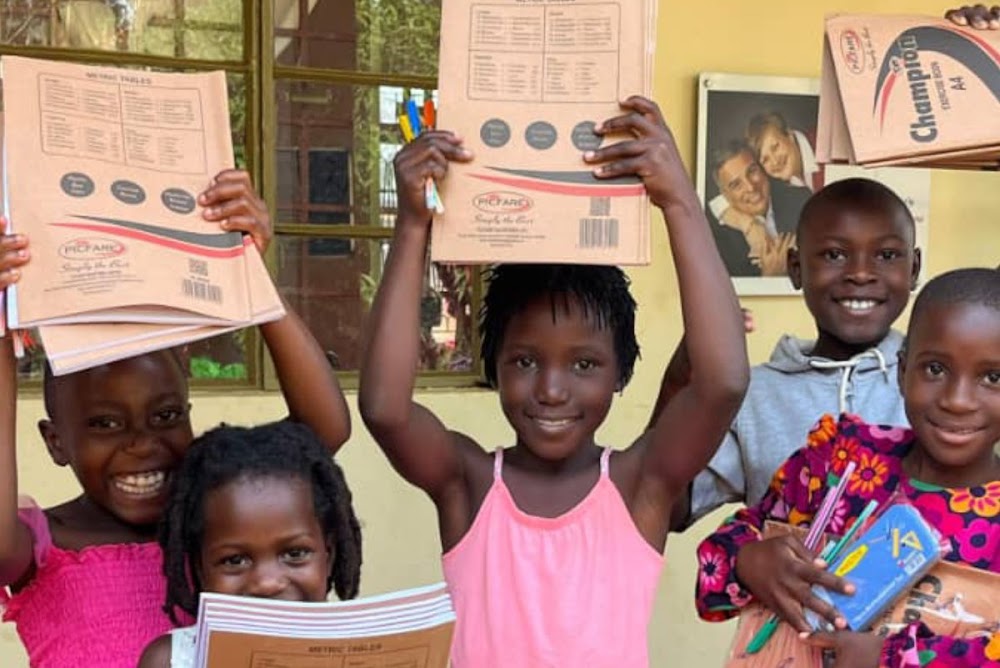 Children holding books and supplies