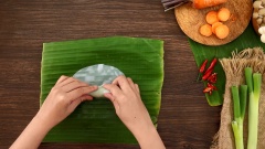 Đặt xà lách và rau thơm lên lá bánh phở, cho nhân rau củ vào giữa. Dùng tay cuốn chặt bánh phở lại và cắt bỏ phần dư 2 đầu của cuốn phở để nhìn gọn và đẹp hơn.