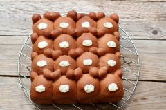 Sau khi bánh chín, lấy bánh ra khỏi khuôn, để lên rack chờ bánh nguội hẳn, nung chảy chocolate trắng, dùng muỗng thoa lên chính giữa làm mũi gấu. Tiếp tục nung chảy chocolate đen, cho vào túi bắt bông kem, cắt 1 lỗ thật nhỏ, vẽ hai mắt và lỗ mũi gấu như hình. Chờ chocolate khô hẳn là có thể dùng. Nếu dùng không hết có thể cho vào hộp đậy nắp kín để bánh không bị khô.