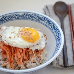 Chuẩn bị 1 phần cơm trắng. Chiên một quả trứng, cho salad củ cải và trứng lên trên tô cơm, rắc mè trắng rang nữa là thưởng thức nào. Món này làm siêu nhanh, ăn siêu ngon, bảo đảm bạn sẽ không bao giờ bị ngán đâu.