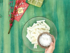 Củ cải chọn củ không quá non cũng như quá già, chọn củ còn tươi. Để làm được 1 hủ của cải ngâm cỡ trung để ăn tết thì mình dùng khoảng 5 củ. Củ cải đem đi rửa sạch rồi thấm khô ráo, để nguyên vỏ rồi cắt bỏ cuống và phần đuôi nhọn. Cắt củ cải thành những thanh dài 10cm. Cho củ cải vào tô hoặc thau, đổ vào 20gr muối hột rồi dùng tay bóp đều đến khi muối hột tan hết, ngâm củ cải 30 phút đến khi thấy củ cải trong lại, mềm dai và ra nước là được. Đem củ cải đi rửa qua nước lạnh 2-3 lần cho bớt mặn, sau đó để ráo.