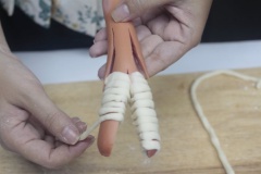 Quấn sợi mì xung quanh phần tay, chân cho cây xúc xích để tạo hình xác ướp.