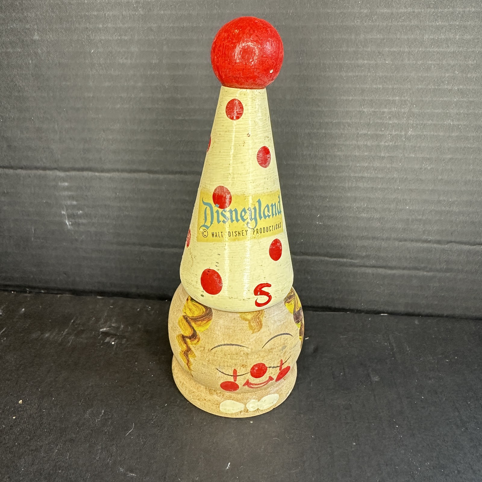 Vintage wooden Disneyland clown stacking toy, three sections showing painted clown face base, polka-dot conical hat with early serif Disneyland logo and number 5, and red sphere top knob